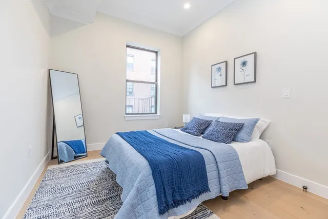 a bedroom with a bed and a window