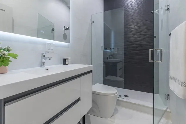 a bathroom with a sink a toilet and shower