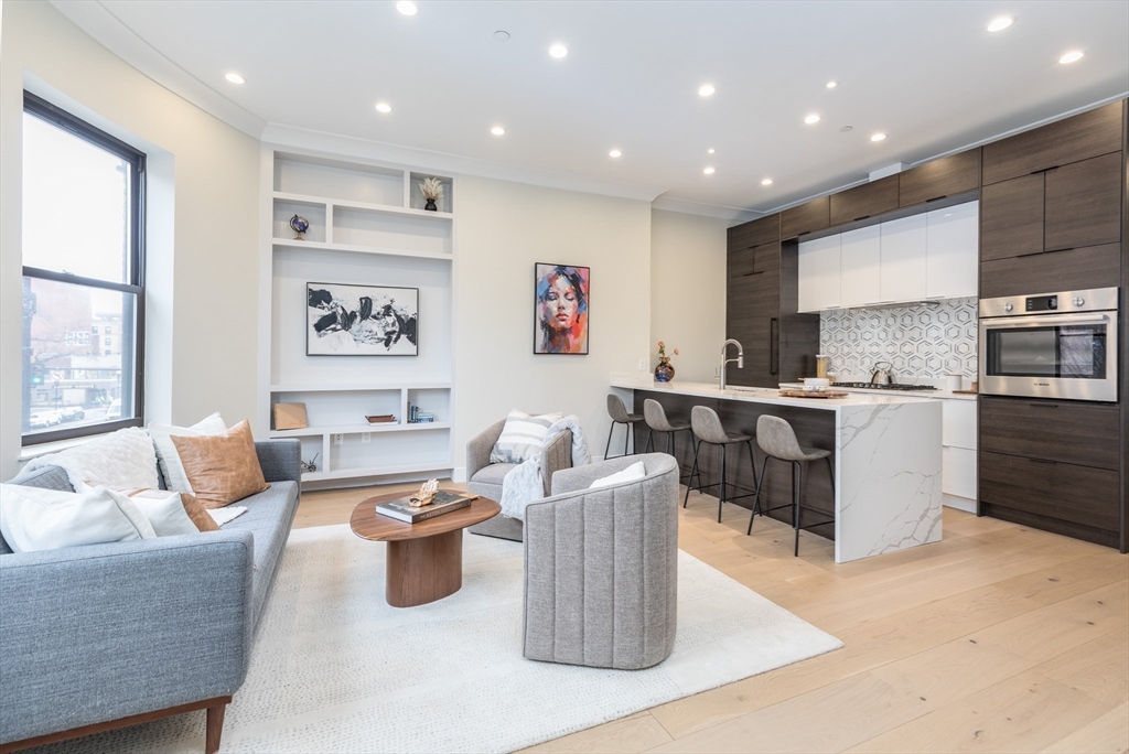 577 Massachusetts Avenue, Unit C Boston, MA 02118 - Photo 7 of 12 a living room with furniture and kitchen view