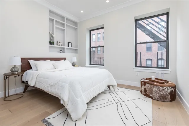 a bedroom with a bed and wooden floor