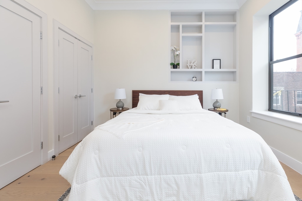 577 Massachusetts Avenue, Unit C Boston, MA 02118 - Photo 10 of 12 a bedroom with a bed and a window