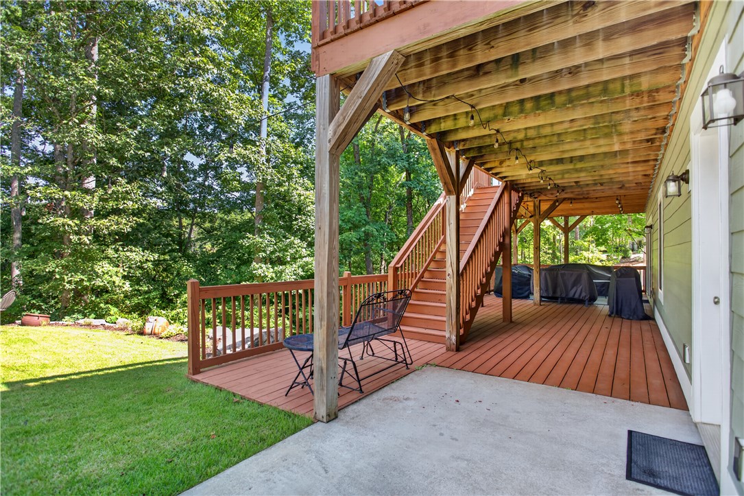321 High Hampton Road Salem, SC 29676 - Photo 35 of 46 An expansive covered wood deck connects seamlessly to a concrete patio and lush green lawn.