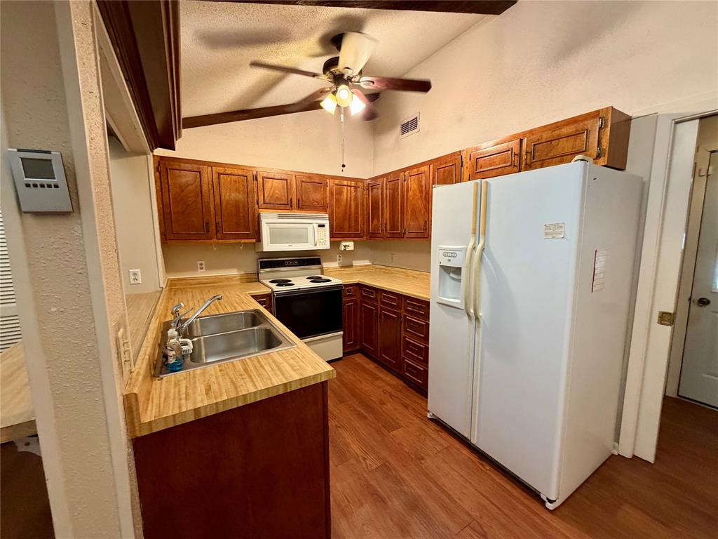 2030 Sycamore Street Paris, TX 75460 - Photo 7 of 24 Kitchen featuring wood-finish flooring, wood cabinetry, and light-toned countertops
