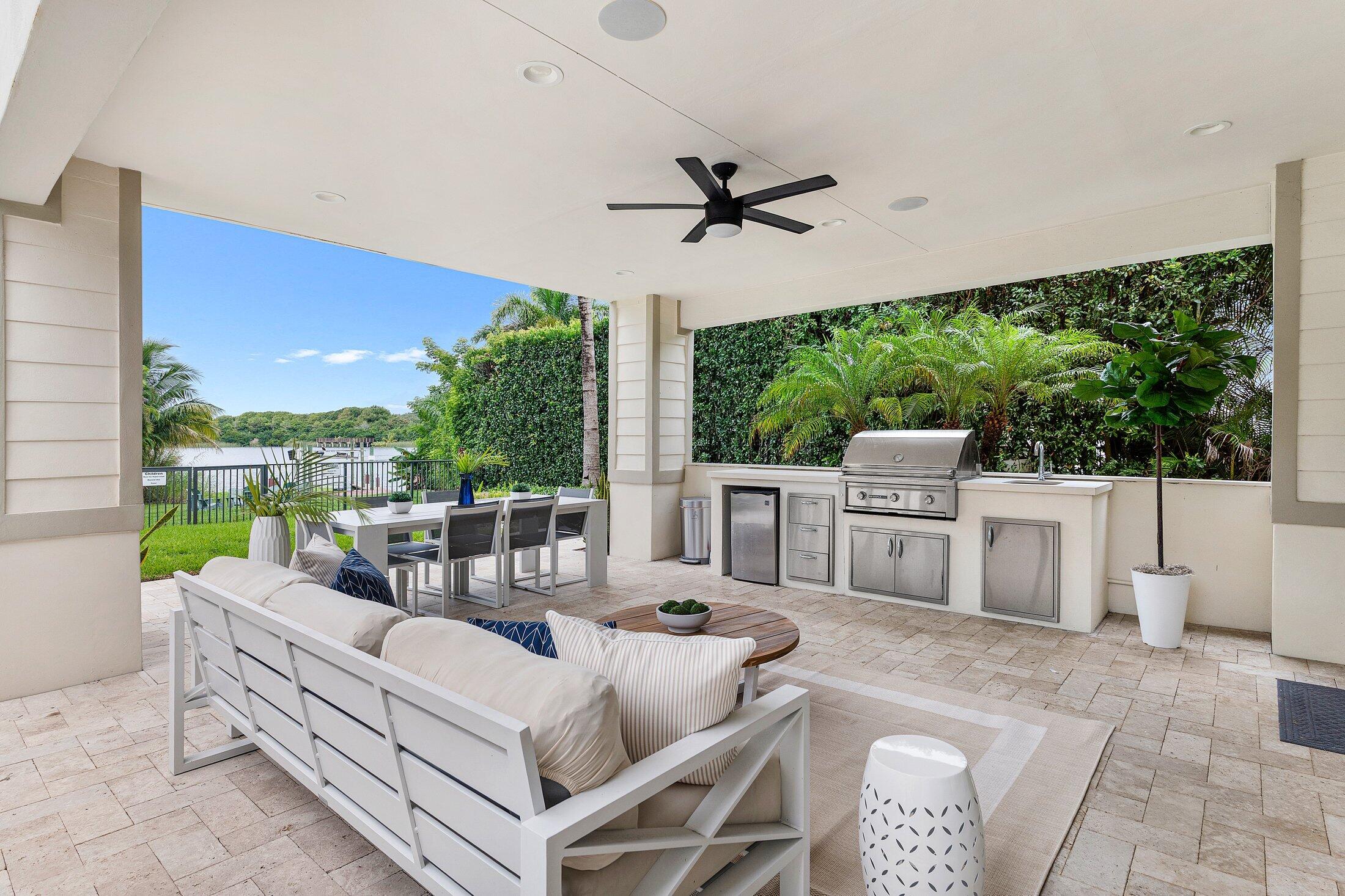 1400 Lake Drive Delray Beach, FL 33444 - Photo 116 of 121 a view of a patio with a table chairs and a floor to ceiling window