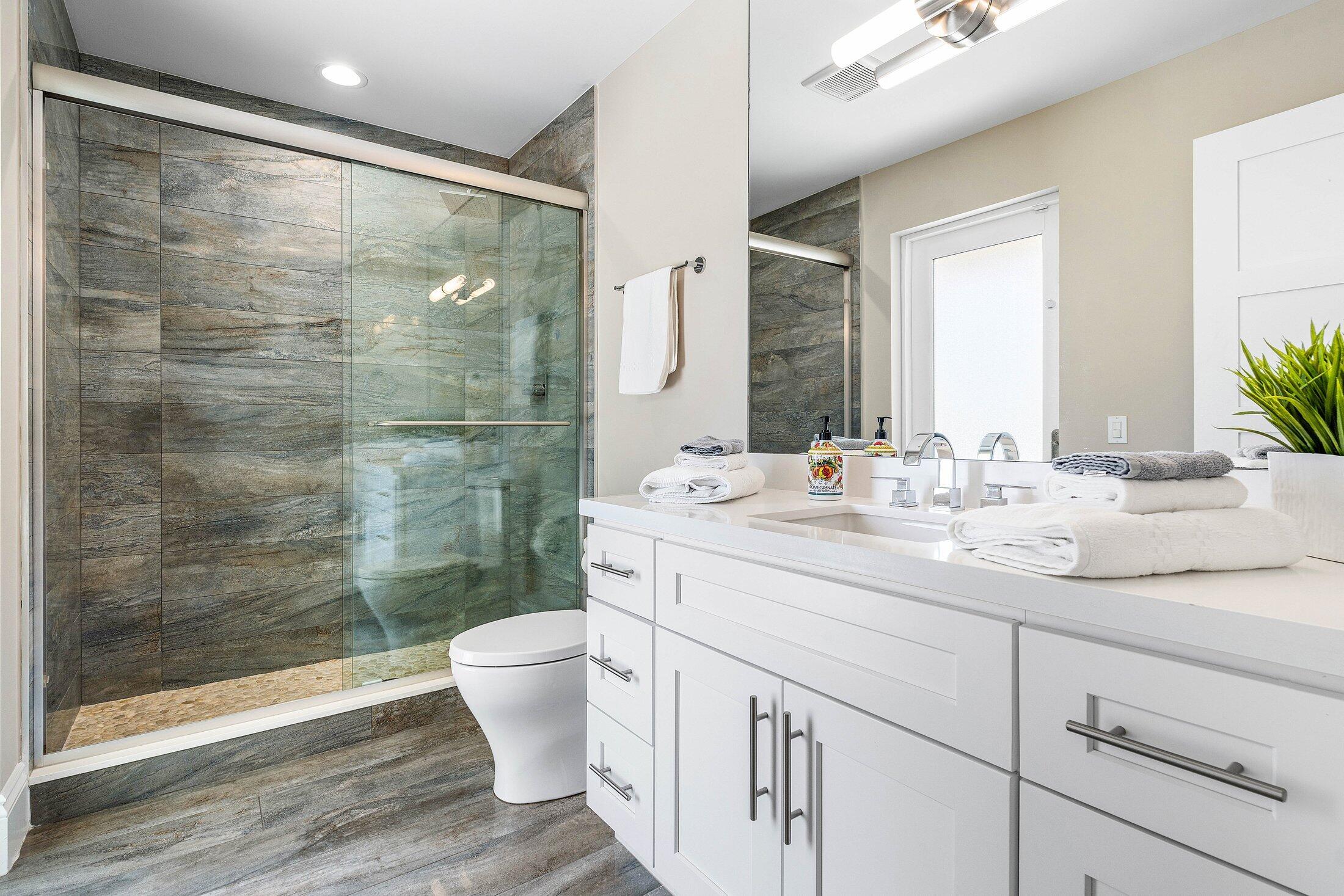 1400 Lake Drive Delray Beach, FL 33444 - Photo 24 of 121 a bathroom with a double vanity sink toilet and shower