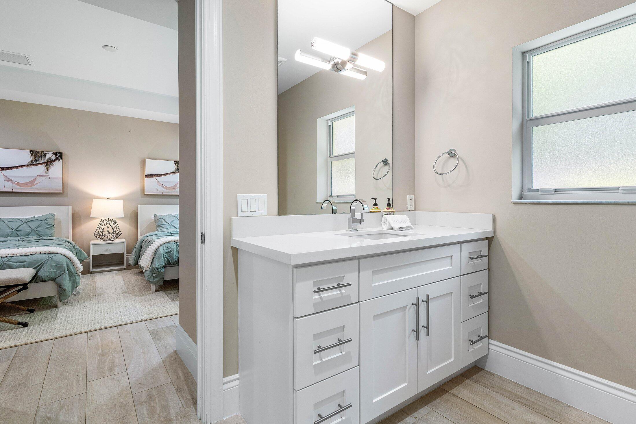 1400 Lake Drive Delray Beach, FL 33444 - Photo 28 of 121 a en suite bathroom with a double vanity sink and a mirror