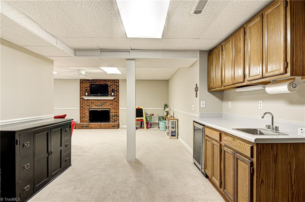 3835 Edgewater Street High Point, NC 27265 - Photo 21 of 30 The basement provides great additional living space. It has a butler sink, counter work space for entertaining, wine refrigerator to keep cold drinks for all ages and additional cabinetry storage.