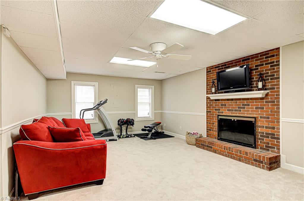 3835 Edgewater Street High Point, NC 27265 - Photo 22 of 30 This bonus area in the basement is perfect for entertaining, working out, and hanging out with the family. The brick fireplace is wood burning.