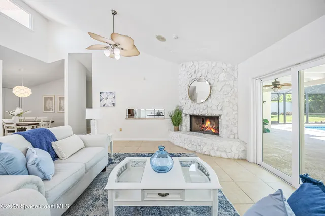 a living room with furniture a fireplace a rug and a window