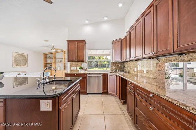 a kitchen with granite countertop a sink stove and cabinets