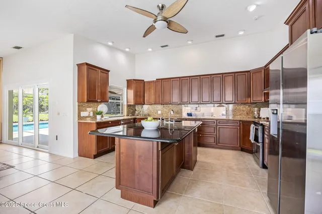 a kitchen with kitchen island granite countertop a sink counter top space appliances and cabinets