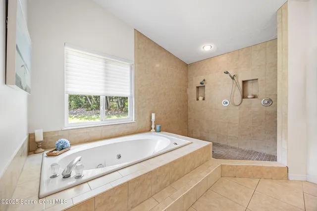 a bathroom with a tub a window and a shower