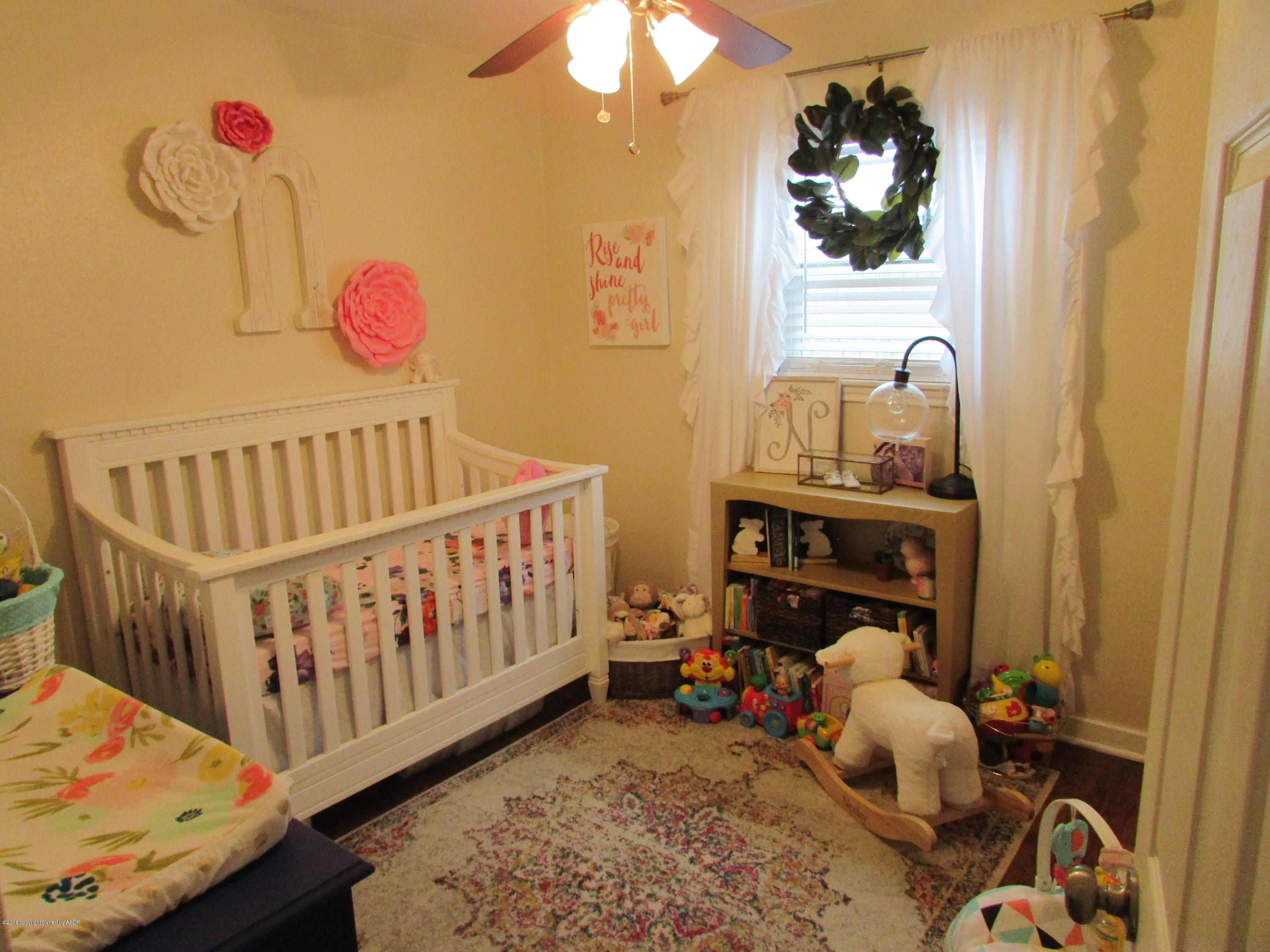 4605 South Travis Street Amarillo, TX 79110 - Photo 13 of 17 a bedroom with a bed and wooden floor