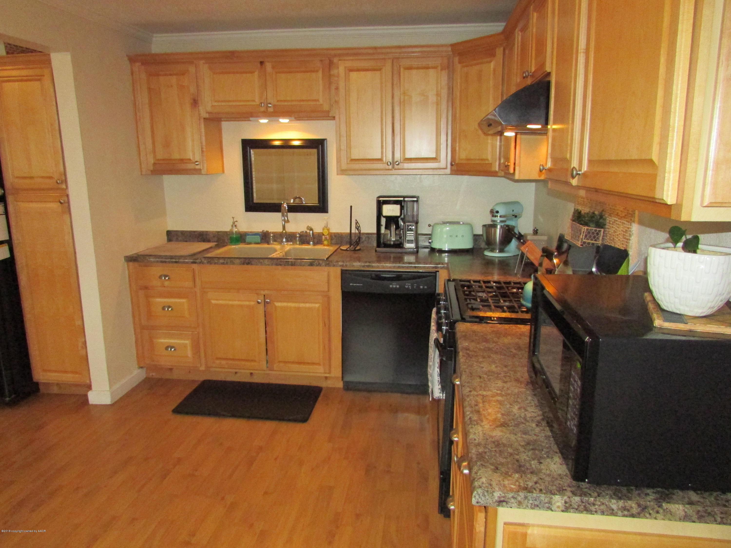 4605 South Travis Street Amarillo, TX 79110 - Photo 4 of 17 a kitchen with stainless steel appliances granite countertop a stove a sink and a microwave