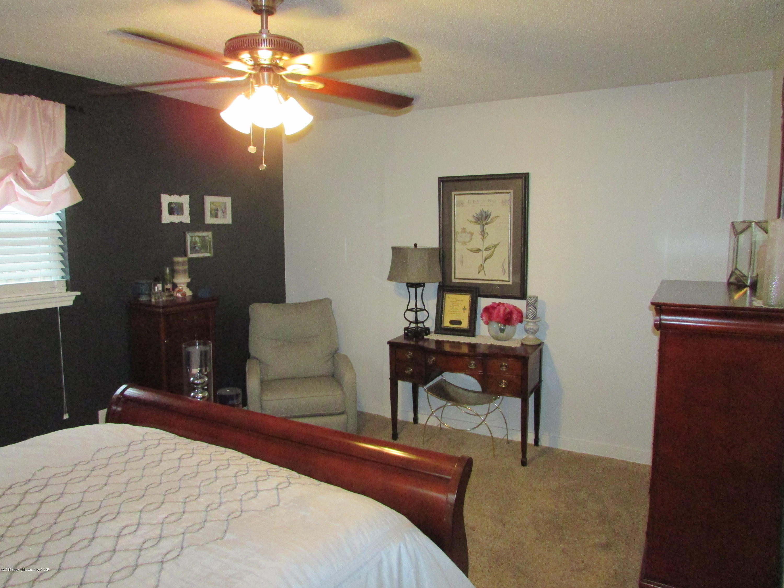4605 South Travis Street Amarillo, TX 79110 - Photo 9 of 17 a bedroom with a bed and a chandelier