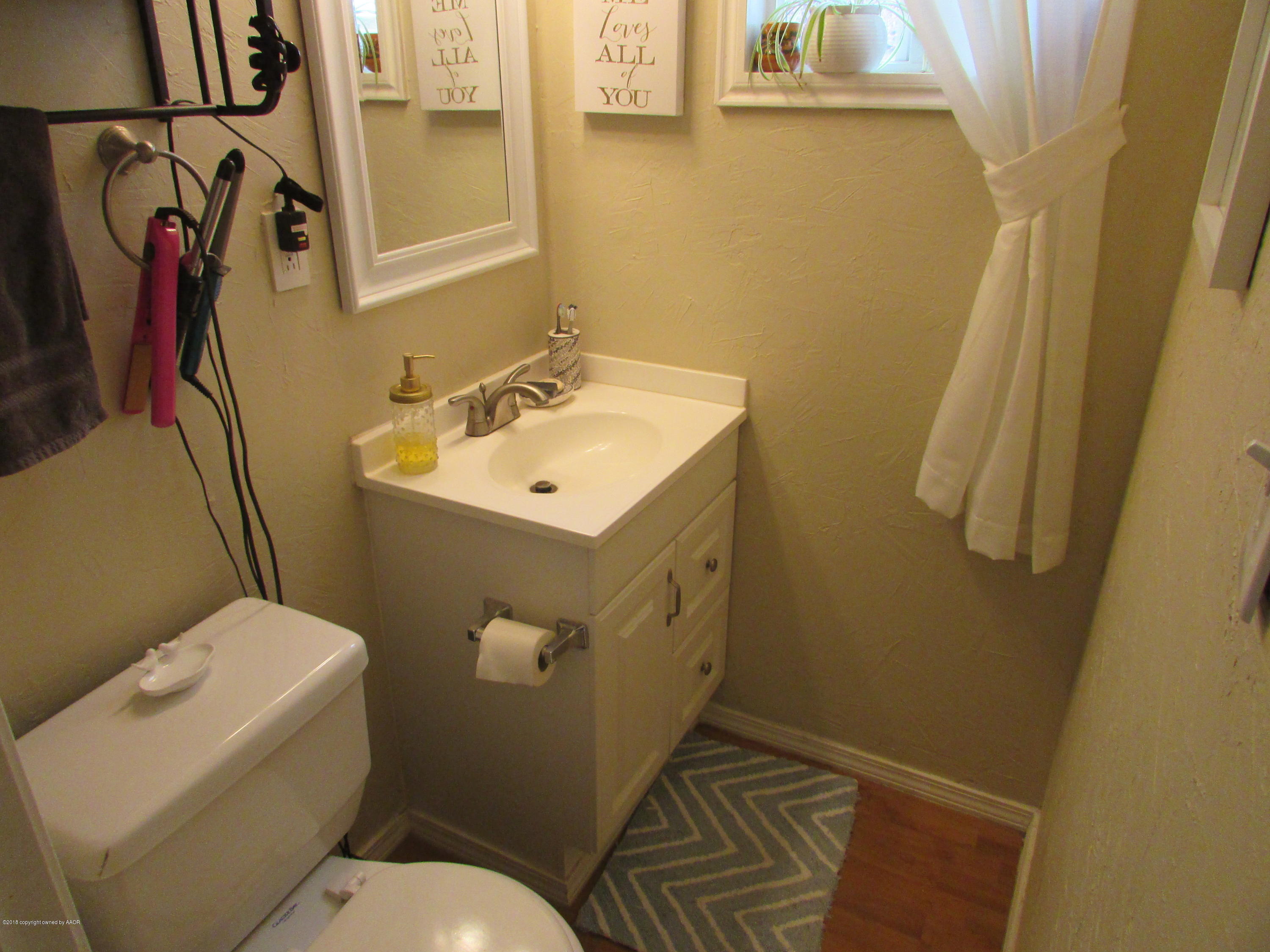 4605 South Travis Street Amarillo, TX 79110 - Photo 10 of 17 a bathroom with toilet sink and mirror