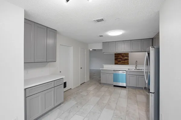 a kitchen with a refrigerator and white cabinets