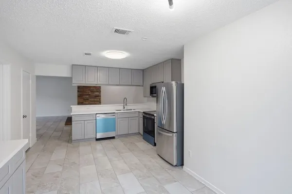 a kitchen with a refrigerator sink and cabinets