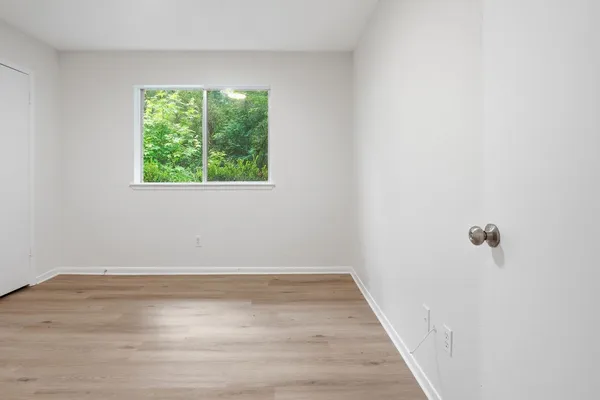 a view of a room with wooden floor and window