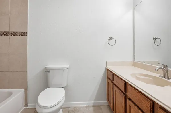 a bathroom with a sink toilet vanity and tub