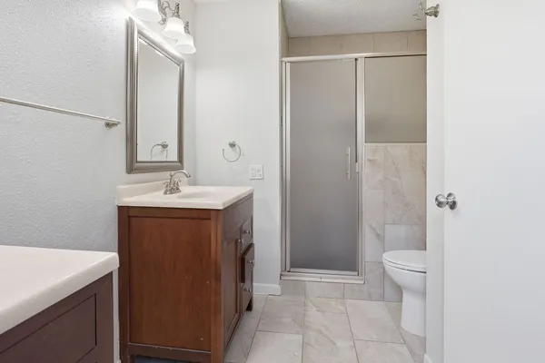 a bathroom with a sink a toilet and shower