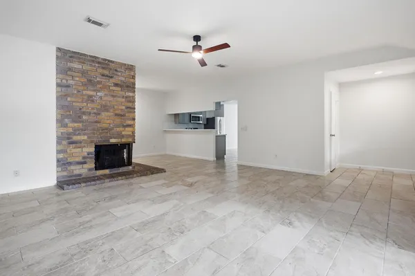 an empty room with fireplace and windows