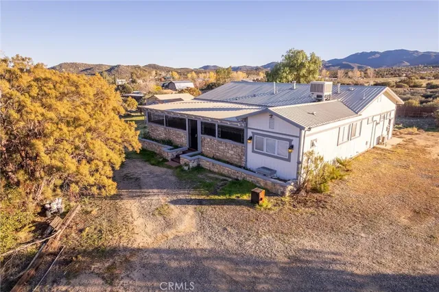 an aerial view of residential house with parking and mountain view