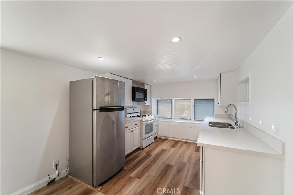 44270 Arya Court Anza, CA 92539 - Photo 6 of 64 a kitchen with a refrigerator a stove top oven and white cabinets