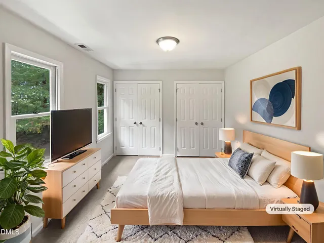 a bedroom with a bed and a flat screen tv