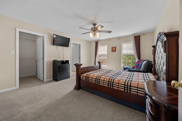 a bedroom with a bed closet and a flat tv screen