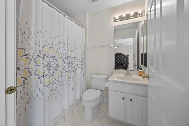 a bathroom with a granite countertop sink a toilet and a mirror