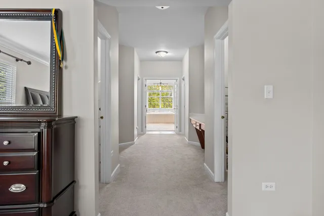 a view of a hallway with closet and a window