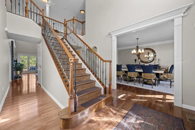 a view of staircase with wooden floor and a chandelier