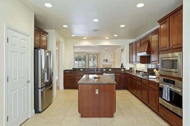 a kitchen with stainless steel appliances granite countertop wooden cabinets a stove top oven a sink and dishwasher
