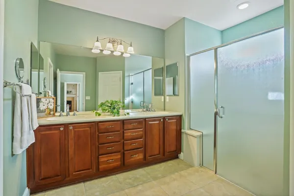 a bathroom with a granite countertop sink a mirror and a shower