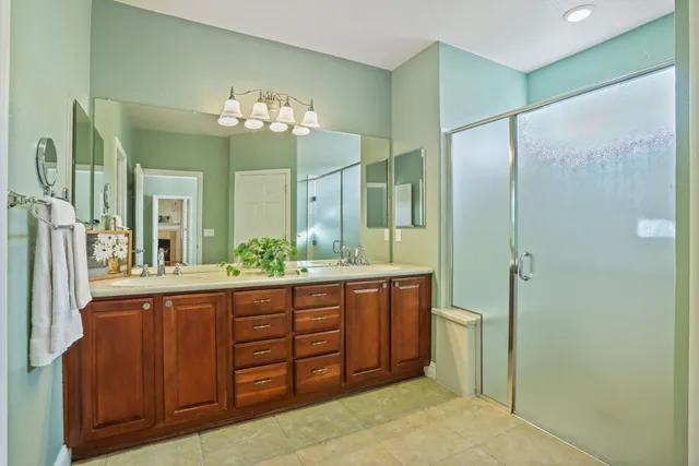 a bathroom with a granite countertop sink a mirror and a shower