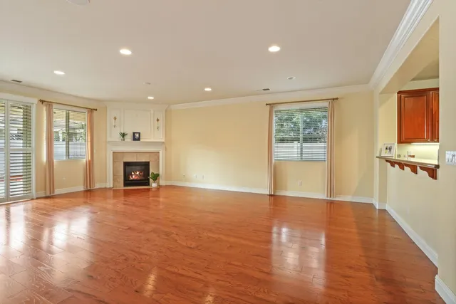 an empty room with wooden floor and fireplace