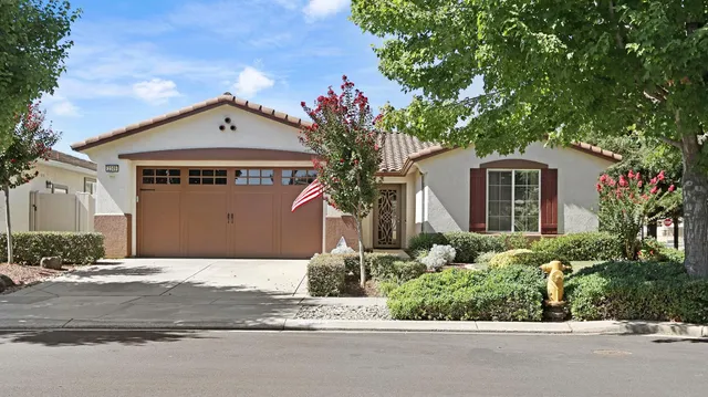 a view of a house with a yard and large tree