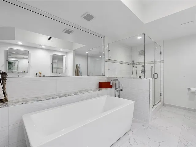 a large white bathroom with a bathtub and a shower