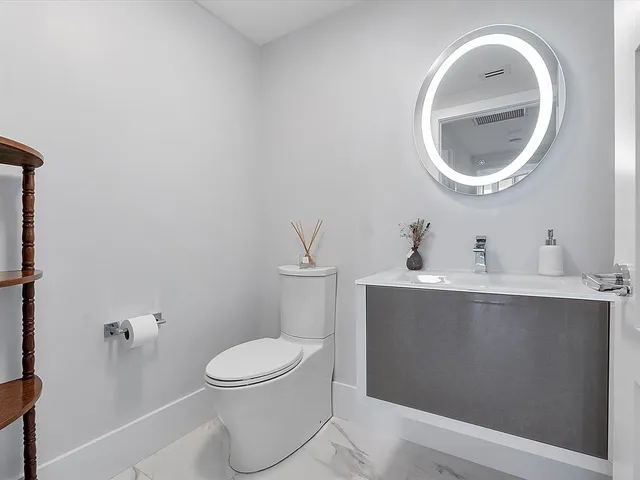 a bathroom with a toilet a sink and mirror