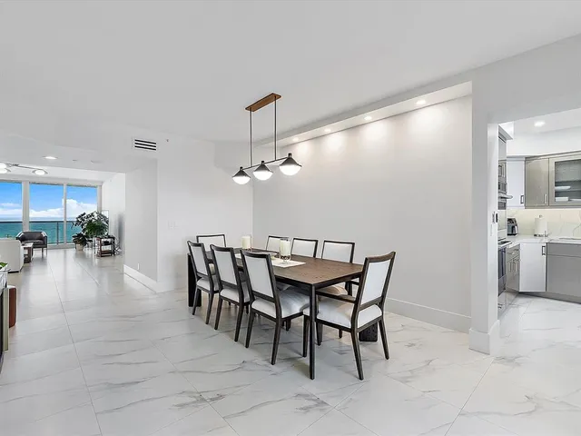 a dining room with furniture and a kitchen view