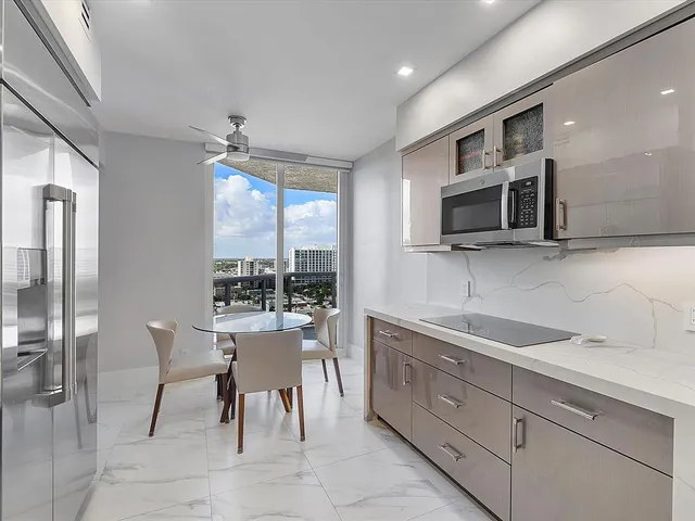 a kitchen with stainless steel appliances granite countertop a sink a stove a microwave with a dining table and chairs