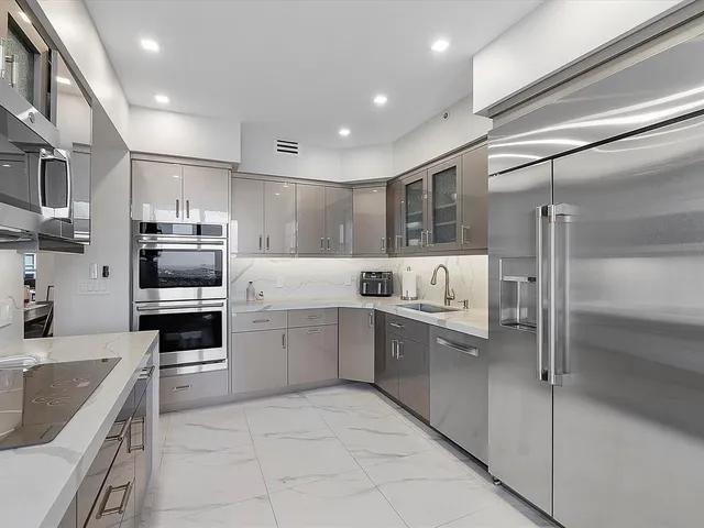 a large kitchen with cabinets stainless steel appliances and a counter top