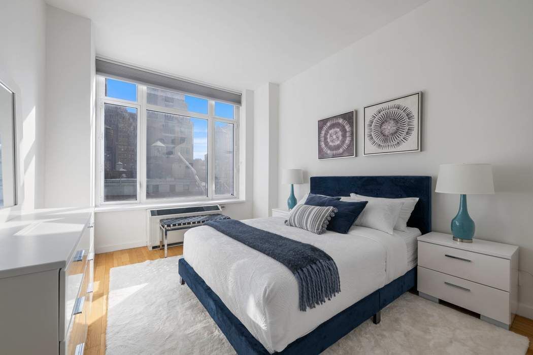 325 5th Avenue, Unit 18F Manhattan, NY 10016 - Photo 6 of 13 a bedroom with a bed and a large window