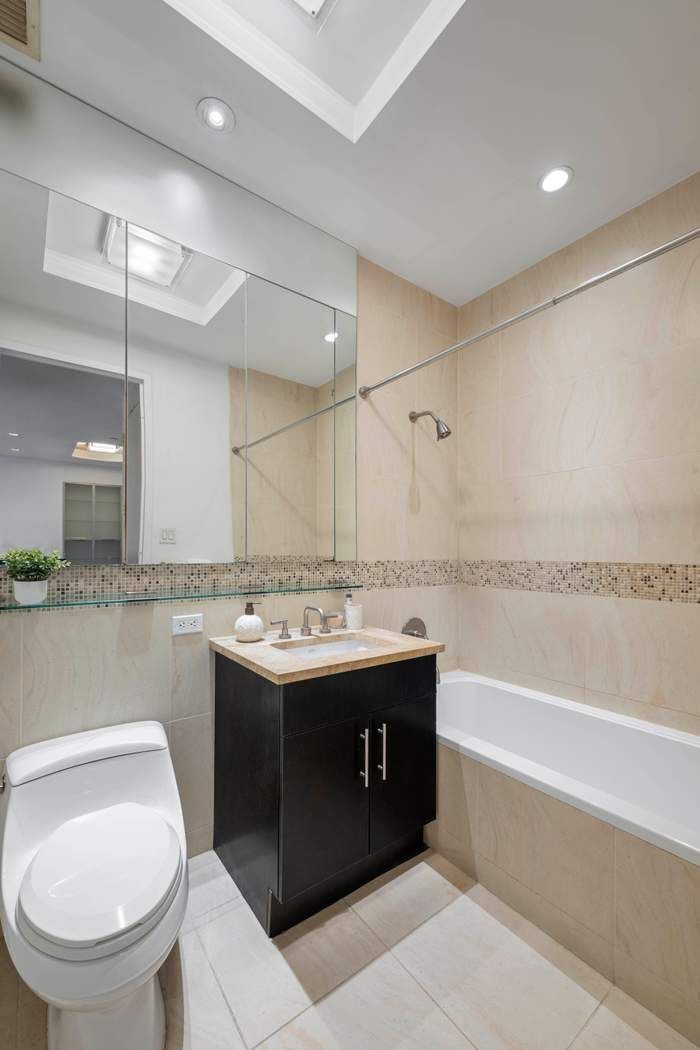 325 5th Avenue, Unit 18F Manhattan, NY 10016 - Photo 7 of 13 a bathroom with a sink a toilet and bathtub