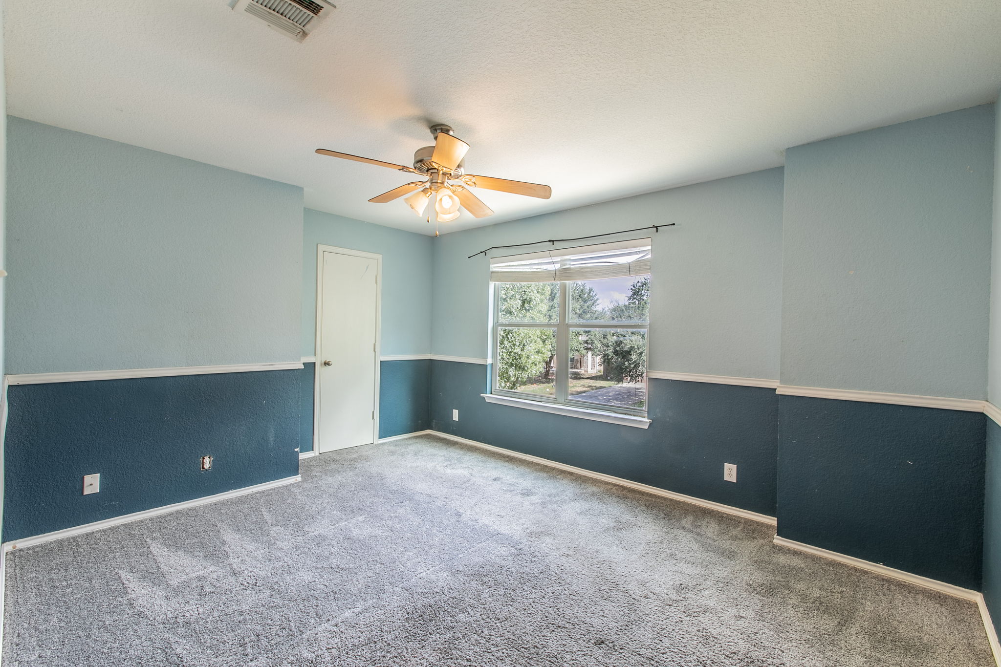 157 Lex Word Kyle, TX 78640 - Photo 24 of 34 Plush carpeting and two-toned walls with classic chair rail molding define this versatile bedroom.