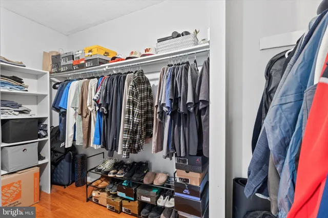 a view of walk in closet with clothes and shoes