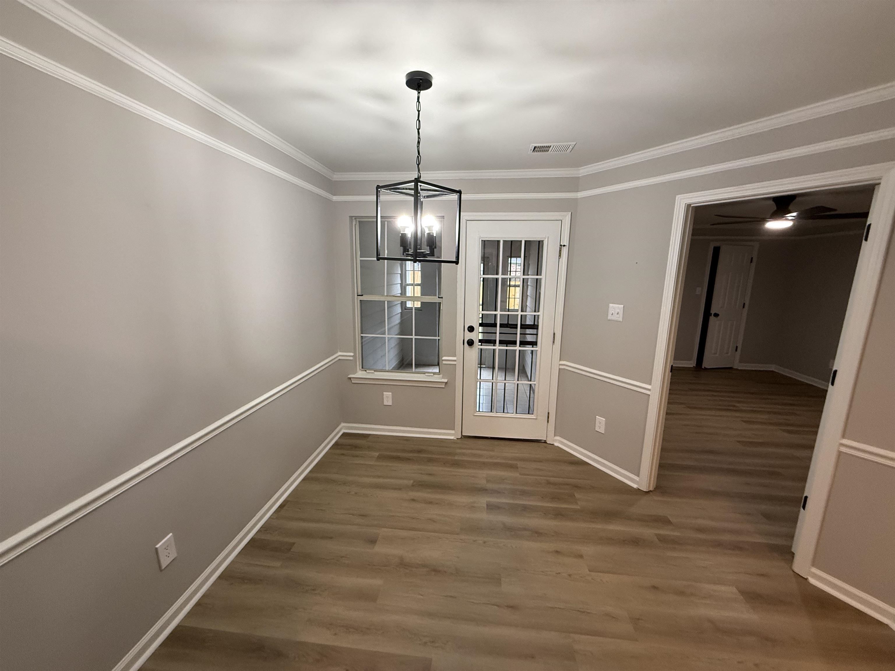 6913 Snyder Road Memphis, TN 38141 - Photo 16 of 20 Dedicated space featuring wood-finish flooring, a contemporary chandelier, two windows, and a glass-paneled door