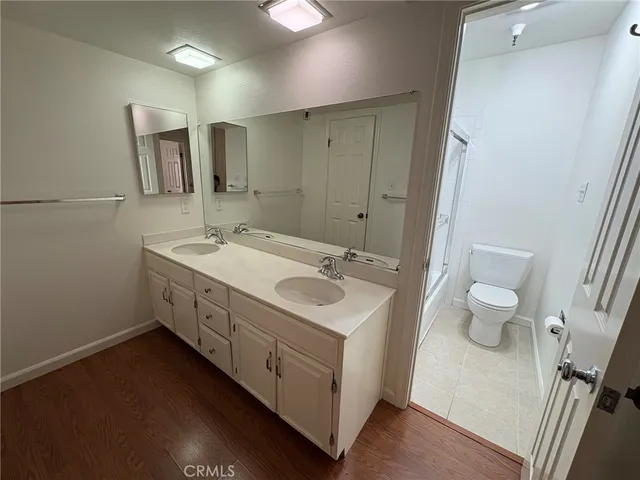 a spacious bathroom with a double vanity sink toilet and a mirror