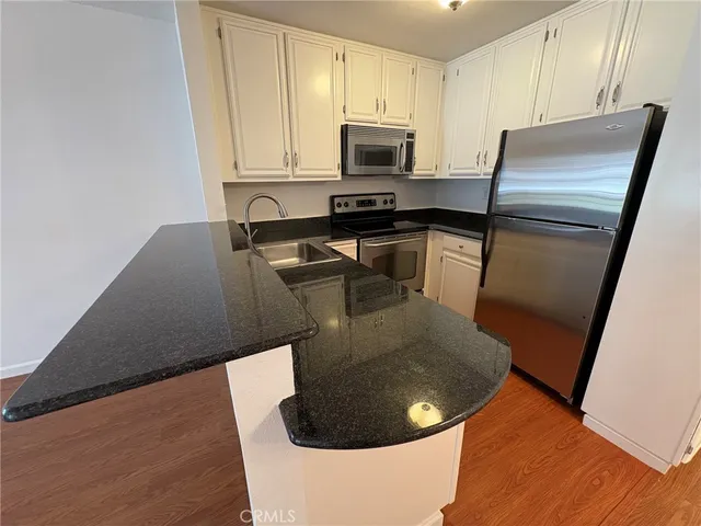 a kitchen with a refrigerator a stove a sink and a counter top space